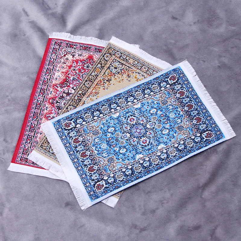 A stack of handwoven Turkish style miniature carpet mats featuring intricate blue, red, and beige patterns.
