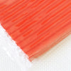 A close-up view of a rectangular block of soft, translucent orange polymer clay modeling material.