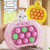 A pink Pop It fidget game console featuring a white rabbit character and colorful buttons, displayed on a wooden surface.
