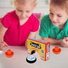 Two children are playing with a mini floating air hockey set and two pushers on a table.