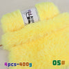 Yellow chunky faux fur yarn in a skein displayed next to a large ball of yellow fluffy yarn.