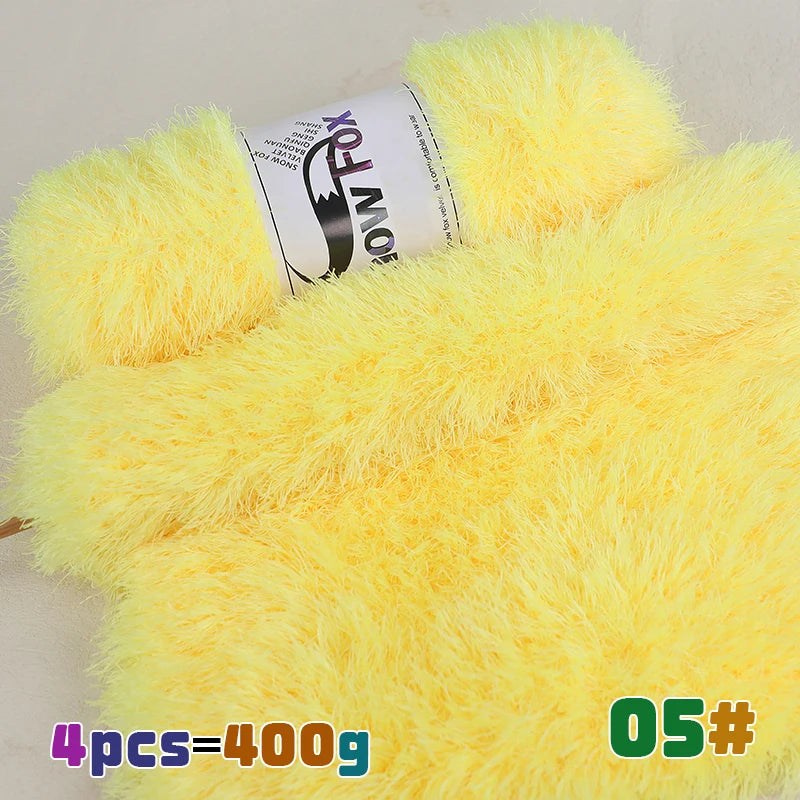 Yellow chunky faux fur yarn in a skein displayed next to a large ball of yellow fluffy yarn.
