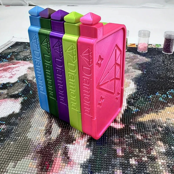 A row of colorful plastic storage trays for diamond painting supplies, featuring various shades of blue, green, purple, and p