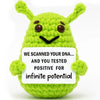 Handmade crochet alien plush toy in lime green with embroidered eyes and a positive message tag