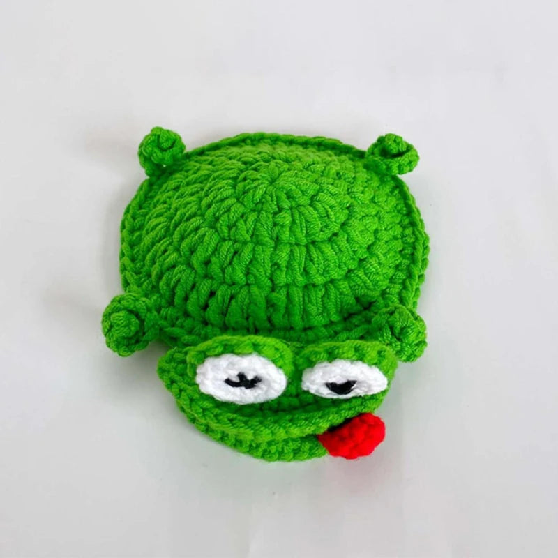 Handmade crochet lizard coaster in bright green with white eyes and red mouth.