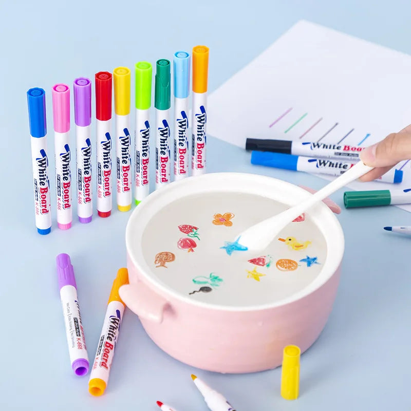 A collection of colorful paint pens and art supplies arranged around a pink bowl for an ink art kit.