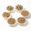 A collection of round gold spacer beads arranged in a circular pattern.