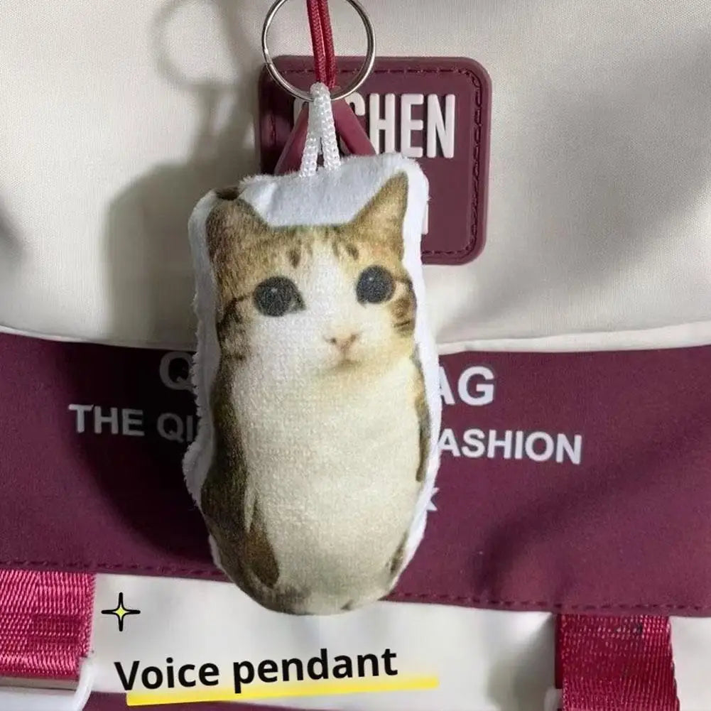 A plush keychain of a cat with brown and white fur is attached to a purple strap.
