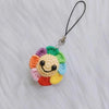 Handmade crochet sunflower decorative smile orb with colorful petals and a black cord.