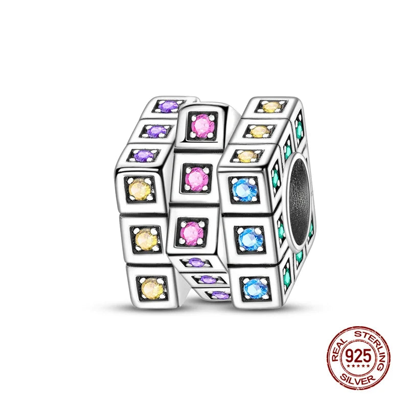 A stack of colorful, square 925 sterling silver rubik's cube charms for bracelets.