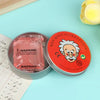 A jar of pink liquid glass crystal slime next to an open tin of red slime and a piece of yellow foam.
