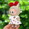 A plush doll dressed in a strawberry party outfit with a red bow and white dress.
