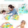 A baby is playing with a yellow and green sensory catch ball rattle toy designed for infants.
