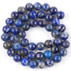 A circular arrangement of polished blue and gray natural sea sediment jasper and turquoise beads for jewelry making