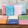 A collection of multicolored raffia paper shreds in various shades including pink, blue, green, and orange, packaged in clear