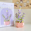 A pink building block set depicting a purple flower bouquet with green stems and leaves.