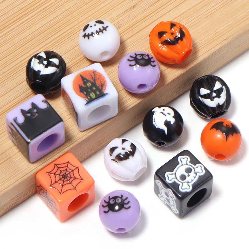 A collection of Halloween themed acrylic beads in black, orange, and purple on a wooden surface.