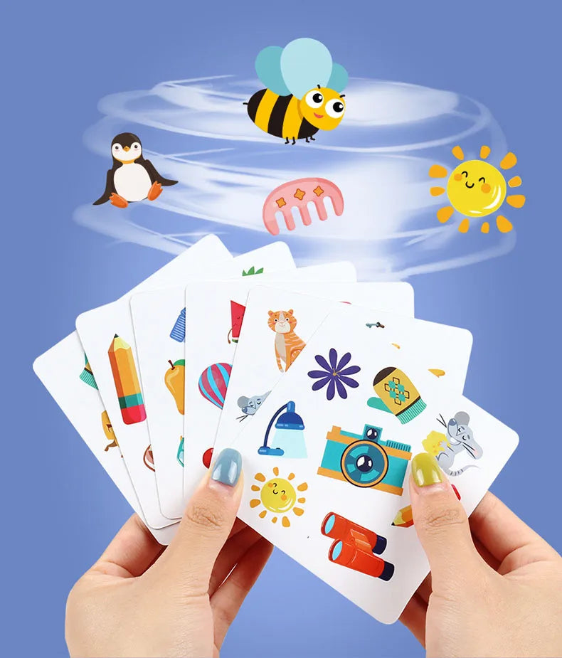 Hands holding a deck of Animal Memory Match Cards with a bee and an owl visible against a blue background.