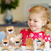 A smiling young girl holds several small, fluffy lion and tiger plush toys.