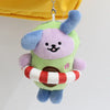 A plush pendant doll of a purple and green creature with blue accents, hanging from a silver chain.