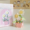 A pink box for a miniature flower bouquet building block set featuring white and yellow flowers.