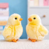 Two fluffy yellow chick plush toys sitting on a white surface.