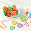 A set of wooden salad pretend play food including various vegetable shapes like carrots, tomatoes, and lettuce on a green pla
