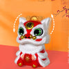 A white and red lion head figurine with gold accents, featuring a glowing face and traditional Chinese characters.