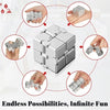 Cube anti-stress en métal argenté, montré sous plusieurs angles tenu par des mains.