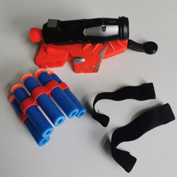 An orange and black superhero web shooter glove toy set with blue and orange foam darts and black elastic bands.
