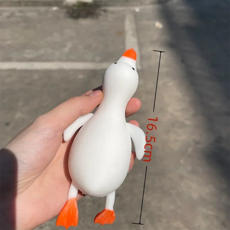 A white and orange jumbo squishy duck stress ball is held in a hand, showing its size with a measurement line.