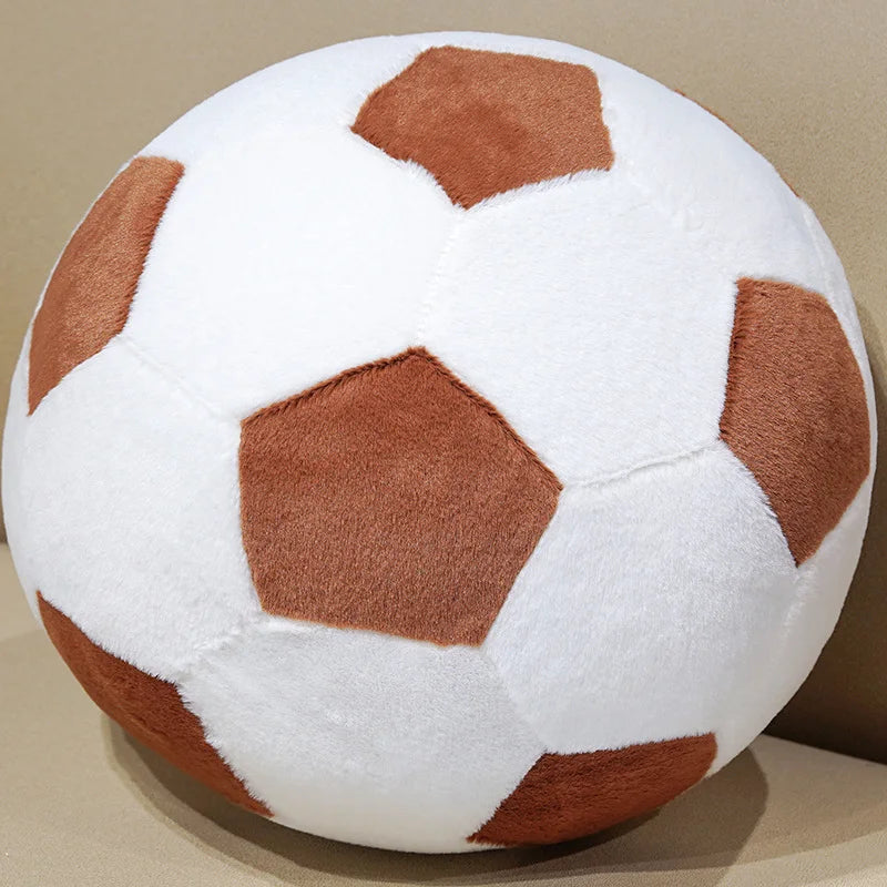 A white plush soccer ball toy with brown hexagonal panels, shown from a close angle.