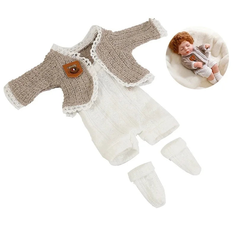 A beige knitted romper outfit for a reborn doll, complete with matching knitted booties.