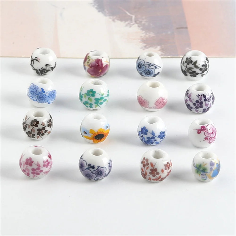 A set of twenty round ceramic flower beads in various colors and patterns for jewelry making.