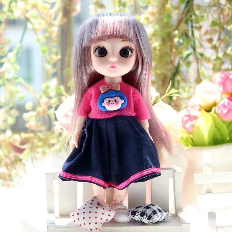 A 17cm articulated princess doll with long pink hair wearing a pink top and dark blue skirt.