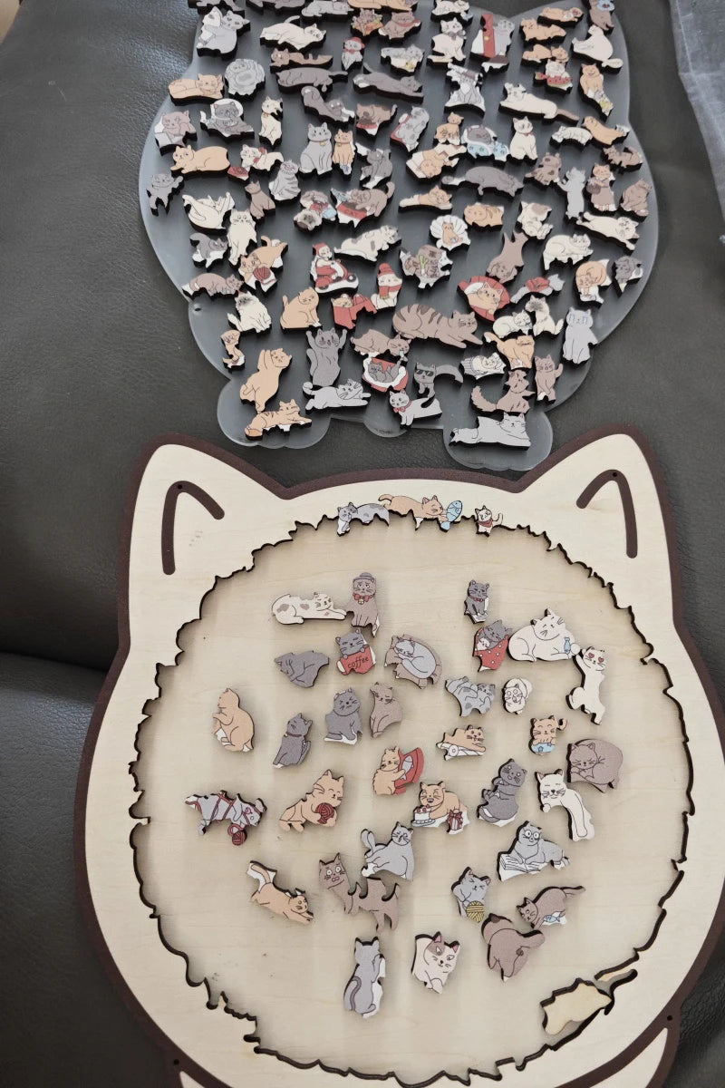 A collection of colorful wooden cat jigsaw puzzle pieces scattered on a dark surface.