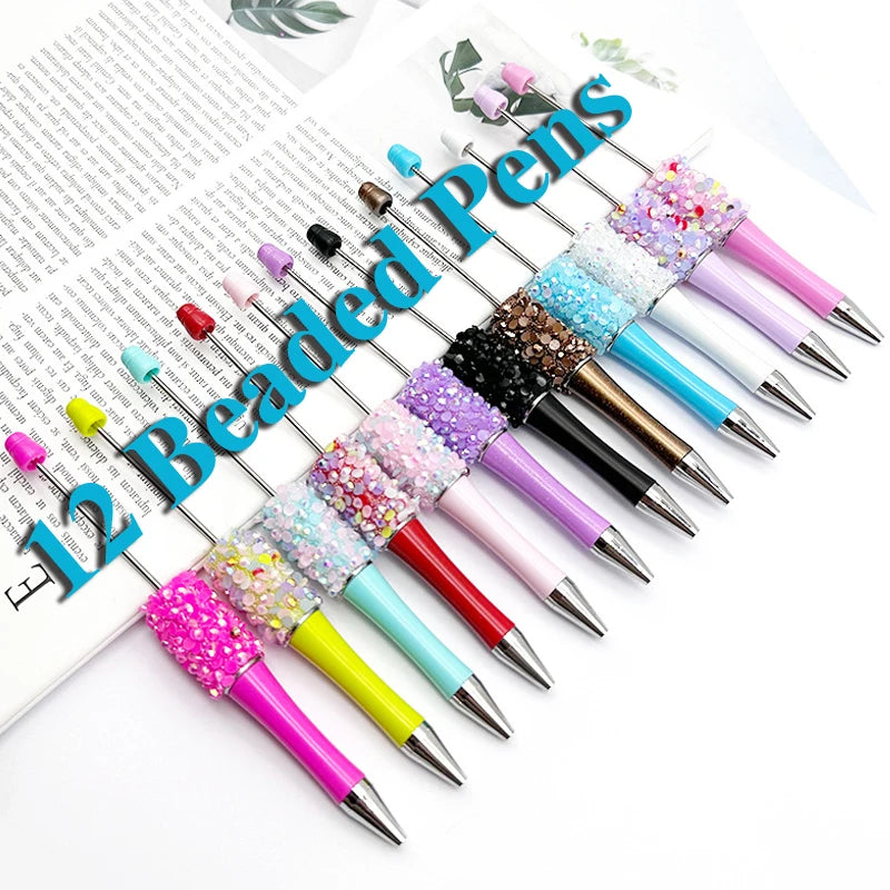 A collection of twelve beaded ballpoint pens in various colors and glitter patterns arranged diagonally on a white background