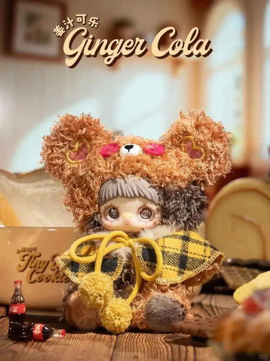 A fluffy brown bear plush charm designed to look like a cookie, featuring pink accents and a yellow plaid accessory.