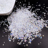 Crushed clear glass crystals scattered on a dark surface next to a white bowl