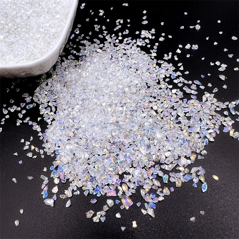 Crushed clear glass crystals scattered on a dark surface next to a white bowl