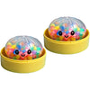 A clear, spherical glitter dumpling squishy toy with colorful, bubbly insides resting in a yellow container.