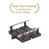 Grey train crossing accessory set with a white striped barrier and support structure