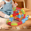A child is playing with a colorful magnetic train track set on a wooden floor.