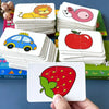 A hand holds a stack of animal matching cards featuring various animals like a lion, a car, and an apple.