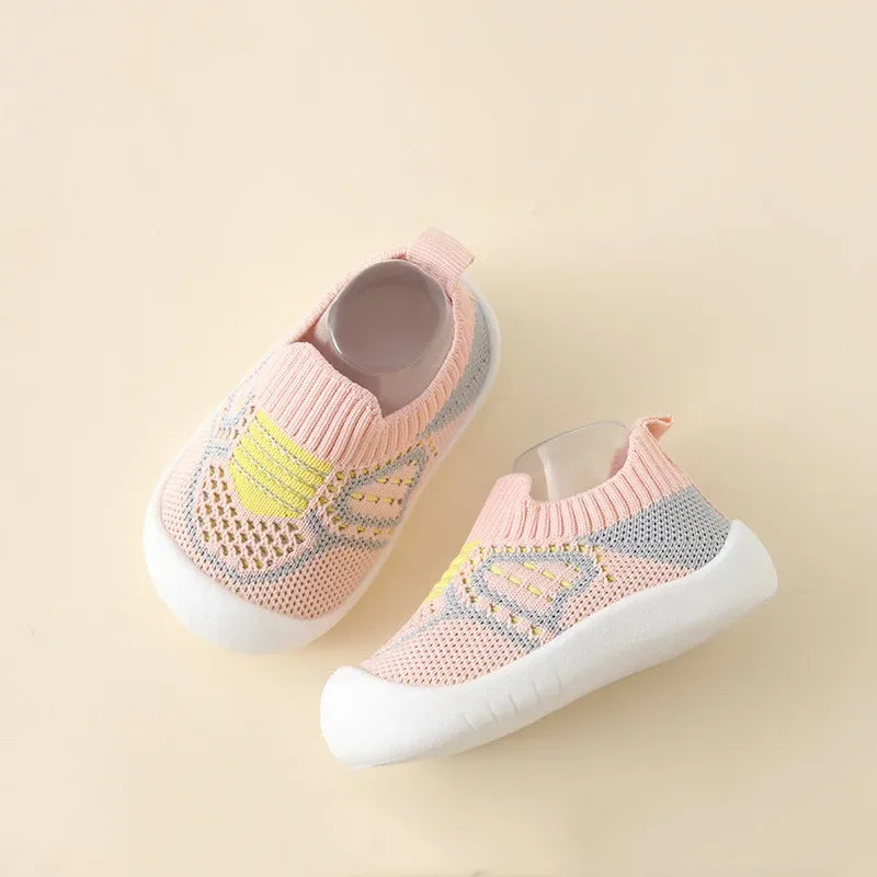 A pair of pink and yellow breathable anti-slip baby first walker shoes shown from above.