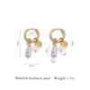 Gold-toned hoop earrings featuring a tiger's eye stone and a translucent white bead.