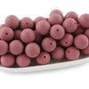 A pile of round, matte pink silicone beads for jewelry making and DIY crafts.