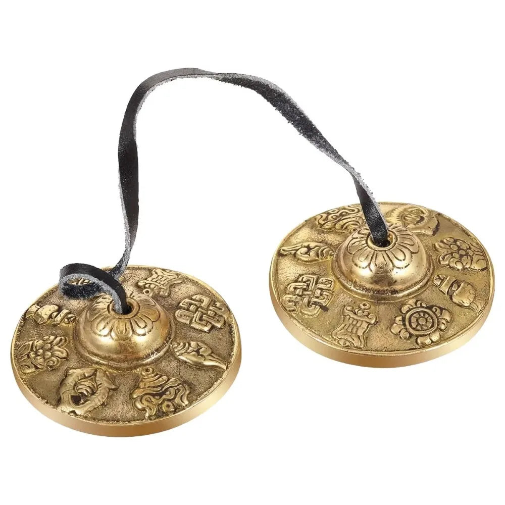 Handcrafted brass tingsha cymbals featuring eight auspicious symbols attached to a black cord.