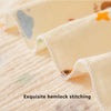 Close-up of a cream-colored baby gauze fabric with delicate hemlock stitching and small colored accents.
