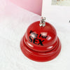 A bright red metal table bell with the text Ring For SEX is shown on a white surface.